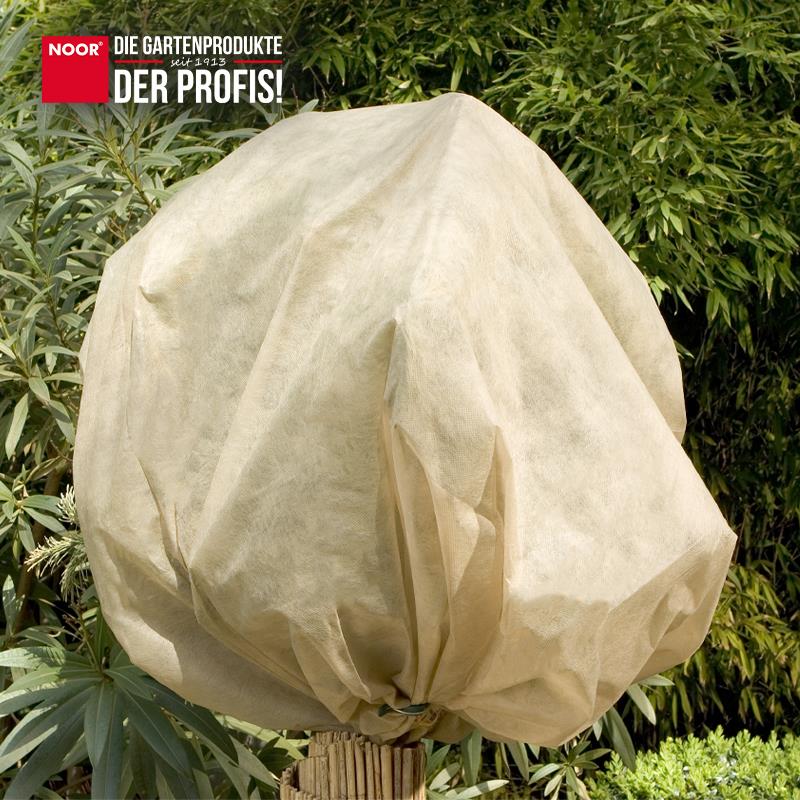 Mit Winterschutzvlies eingepackte Sträucher als optischer Akzent im winterlichen Garten