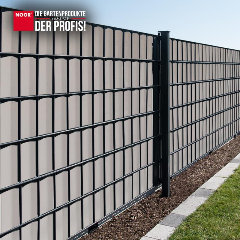 Modern gestalteter Gartenzaun mit durchgängig montierten PVC-Sichtschutzstreifen als Wind- und Sichtschutz