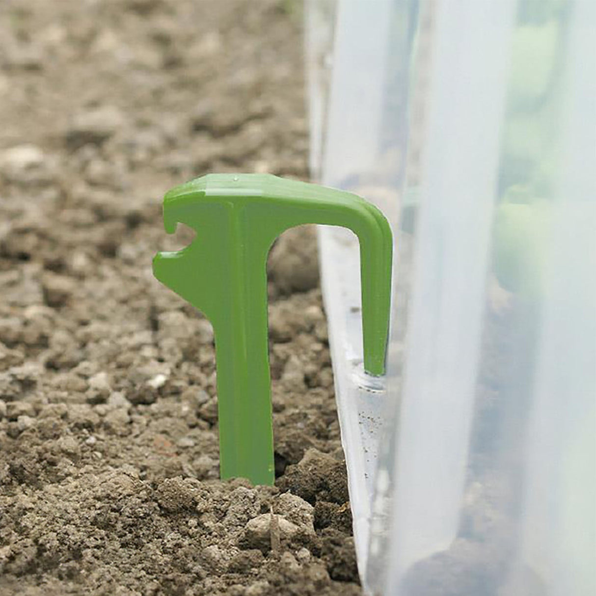 Hellgrüne Mehrzweck-Heringe von NOOR aus Kunststoff zur Befestigung und Belüftung von Pflanztunneln im Garten.