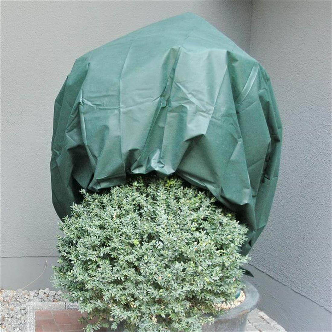 Mit buntem Winterschutzvlies eingepackte Sträucher als optischer Akzent im winterlichen Garten