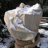 Mit Winterschutzvlies eingepackte Sträucher als optischer Akzent im winterlichen Garten