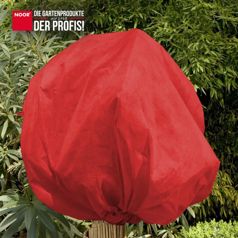 Mit buntem Winterschutzvlies eingepackte Sträucher als optischer Akzent im winterlichen Garten