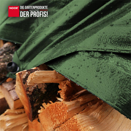 Brennholzstapel im Außenbereich, geschützt durch eine wasserdichte Holz-Abdeckplane gegen Regen und Schnee