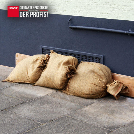 Gestapelte Jute-Sandsäcke als wirksame Barriere gegen Wasser bei Überflutungen und Starkregen