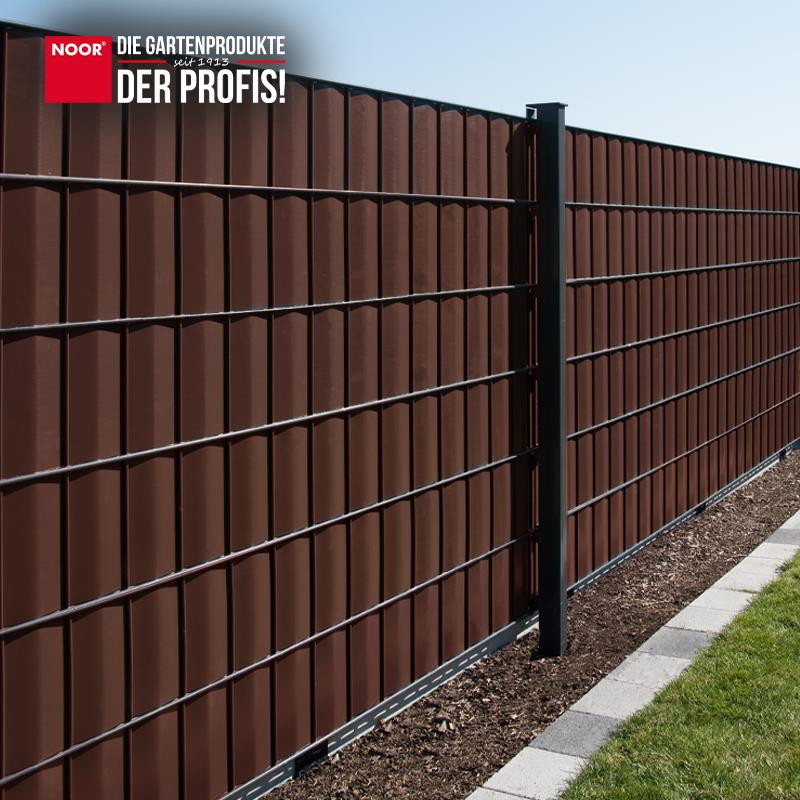 Modern gestalteter Gartenzaun mit durchgängig montierten PVC-Sichtschutzstreifen als Wind- und Sichtschutz