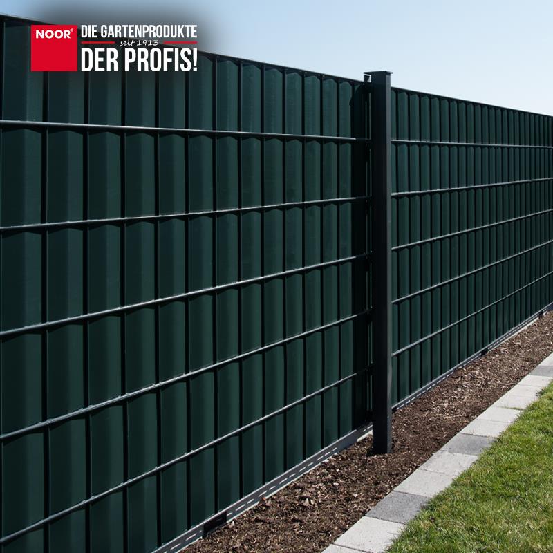Modern gestalteter Gartenzaun mit durchgängig montierten PVC-Sichtschutzstreifen als Wind- und Sichtschutz