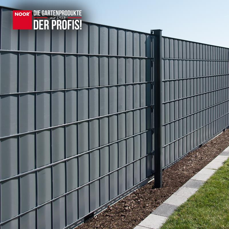 Modern gestalteter Gartenzaun mit durchgängig montierten PVC-Sichtschutzstreifen als Wind- und Sichtschutz