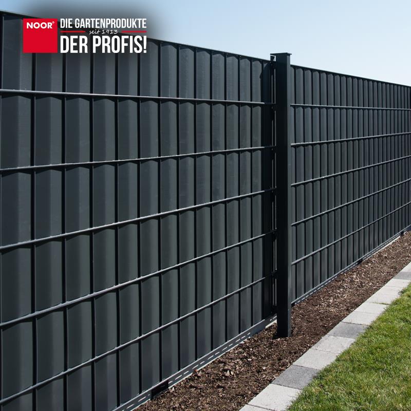 Modern gestalteter Gartenzaun mit durchgängig montierten PVC-Sichtschutzstreifen als Wind- und Sichtschutz