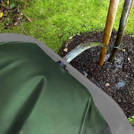 Gefüllter grüner FROGBAG ToGo Wasserbeutel mit Schraubverschluss auf einer schwarzen Antirutschmatte liegend.